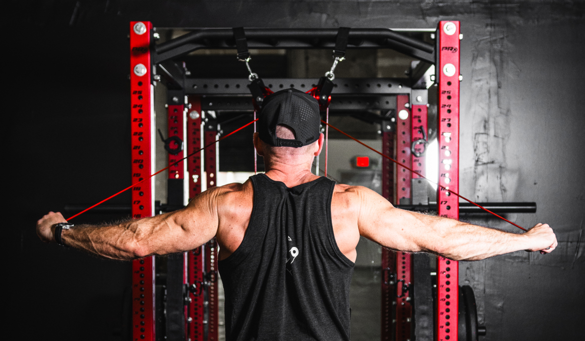 Man performing a cable chest fly workout in a home gym setup.