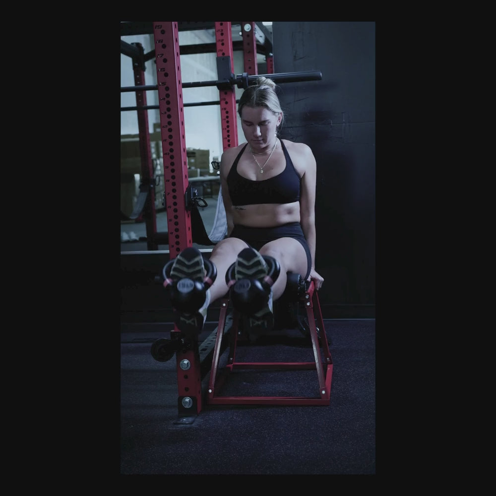 The image shows a woman performing an exercise using the Bullet Pulley Anchor Pad, highlighting its use in a home gym setting. The gym equipment is prominently featured with a focus on functionality and fitness performance.